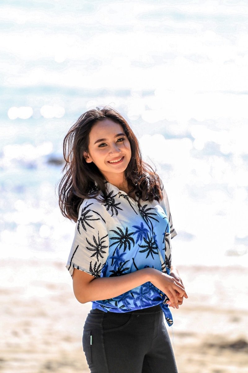 woman in white and blue floral shirt and blue denim shorts